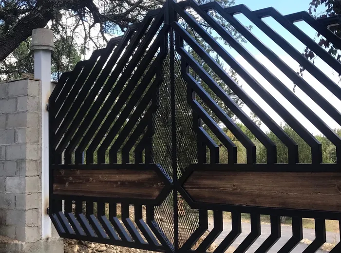 Close view of the centre of the gate where the diagonals mitre together, the timber band meeting at a point and a strip of diamond mesh running down behind the joint.