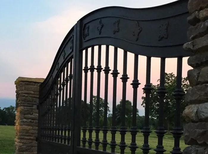 Angled view of the Ham Gate at dusk, showing the S-curve of the top rail against the sky.