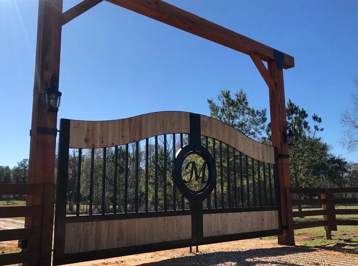 Looking up at a monogrammed build from one side, the wave of the top rail against clear blue sky and lanterns hung on the timber posts either side.