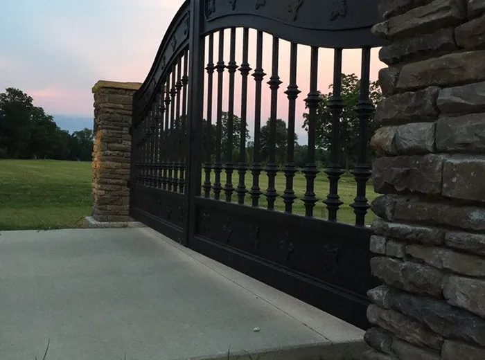The Ham Gate from the driveway approach, both leaves closed against a clouded sky.