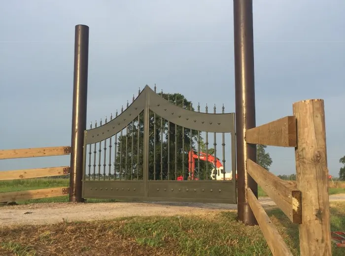 The gate viewed from a distance across the lawn, set into a wooden fence line.